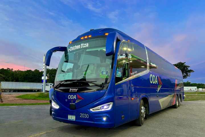 a blue bus parked on the side of a road