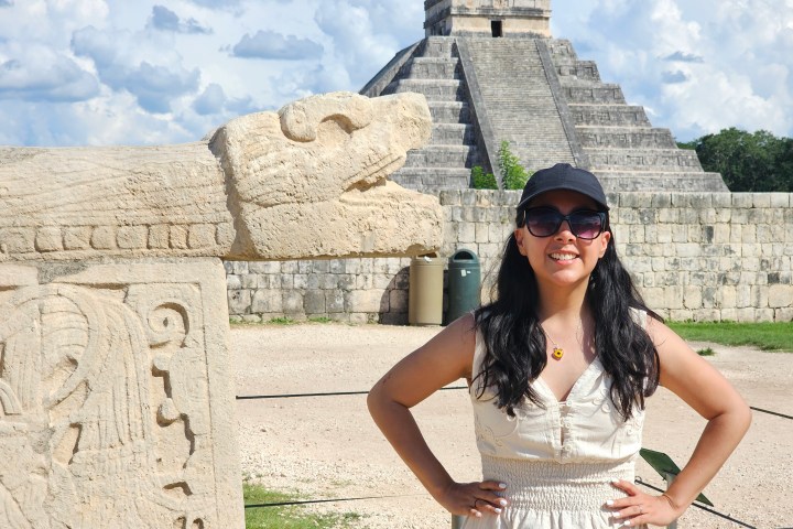 a woman standing in front of a stone building