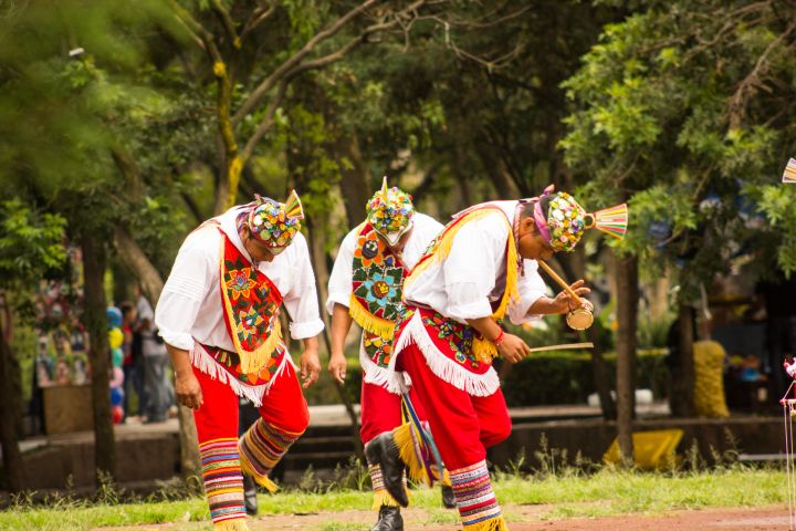 a group of people standing on top of a grass covered field