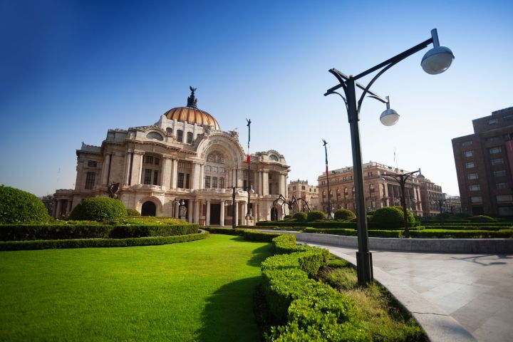 a large brick building with green grass