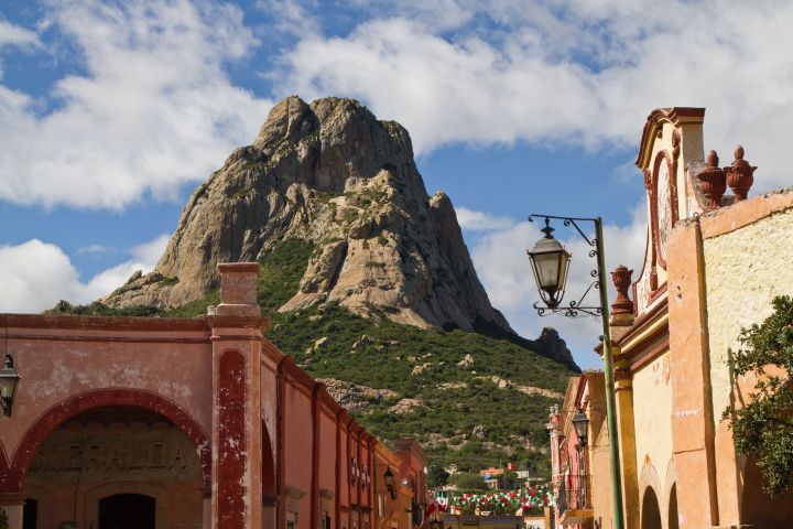 a large brick building with a mountain in the background