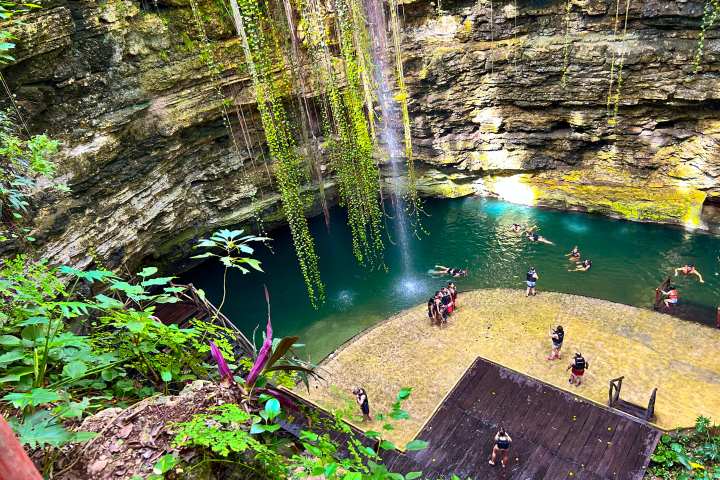 a group of people standing next to a waterfall