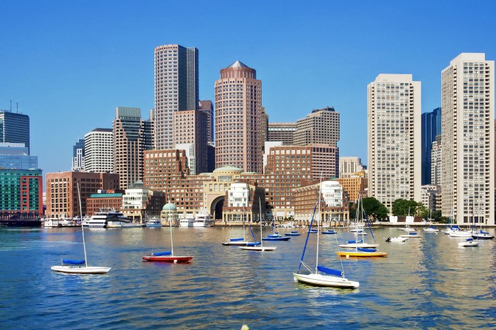 a small boat in a body of water with a city in the background