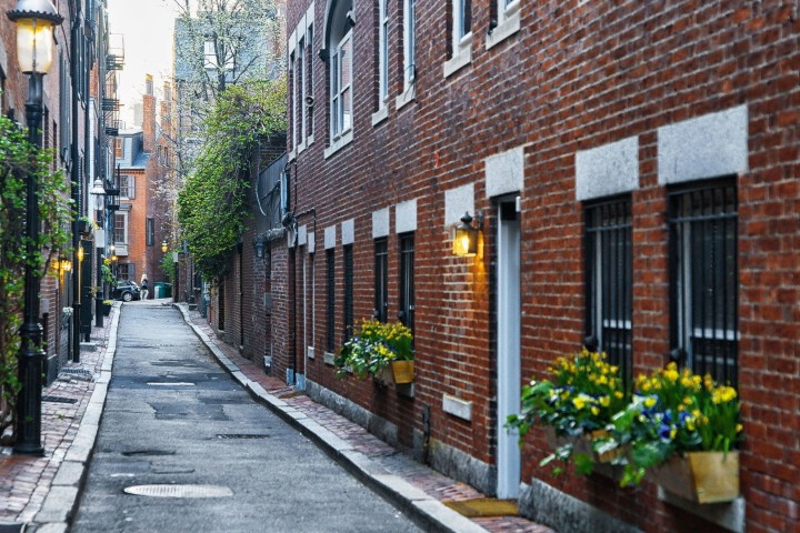 a street scene with focus on the side of a brick building with Beacon Hill in the background