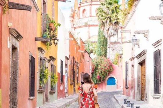 a person walking down a sidewalk in front of a building
