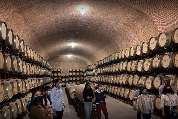 a group of people standing in front of a barrel