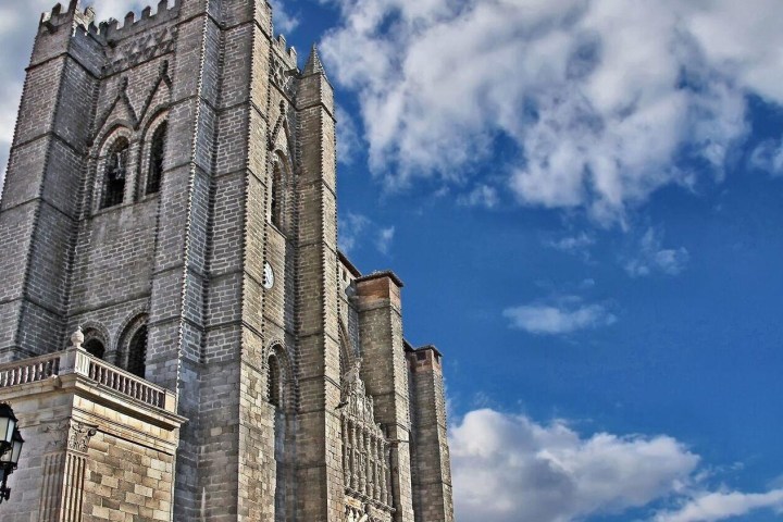 a large stone building with a clock tower on a cloudy day