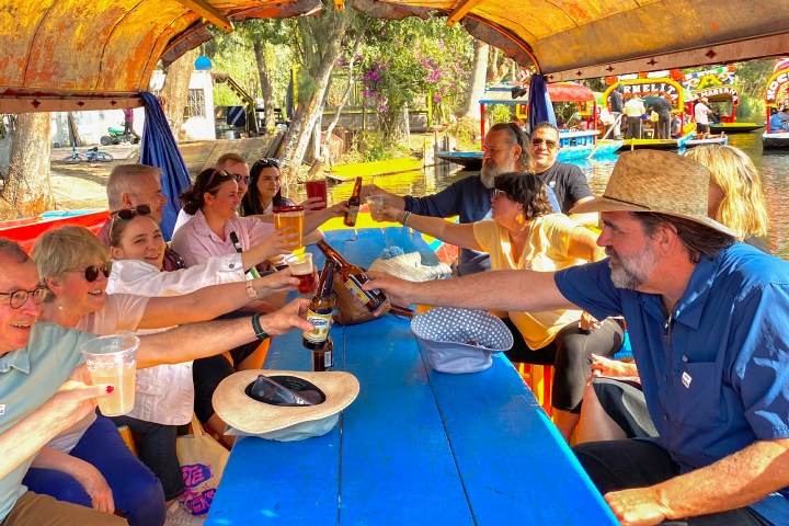 a group of people sitting at a table with a blue umbrella