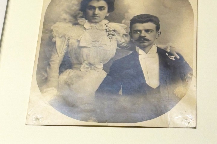Vintage wedding portrait of a couple in formal attire on a sepia-toned photo.