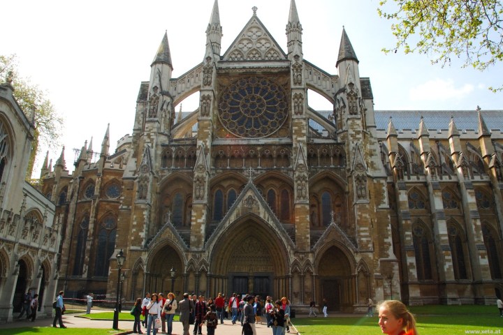a group of people standing in front of a church with Westminster Abbey in the background