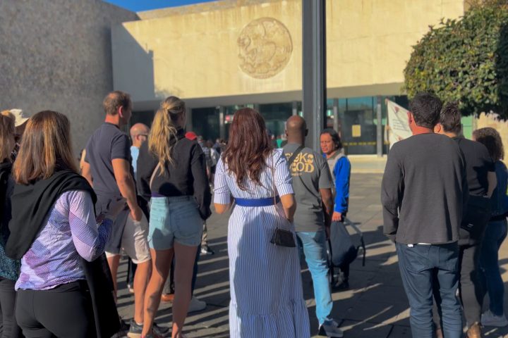 a group of people standing on a sidewalk