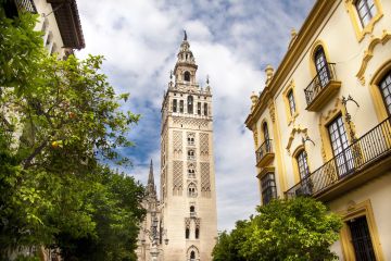 a large tall tower with a clock on the side of Giralda
