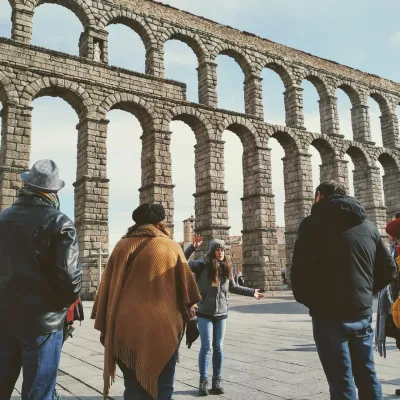 a group of people standing in front of Aqueduct of Segovia