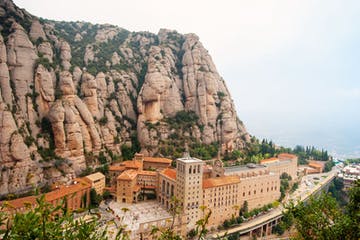 a large mountain in the background with Montserrat in the background