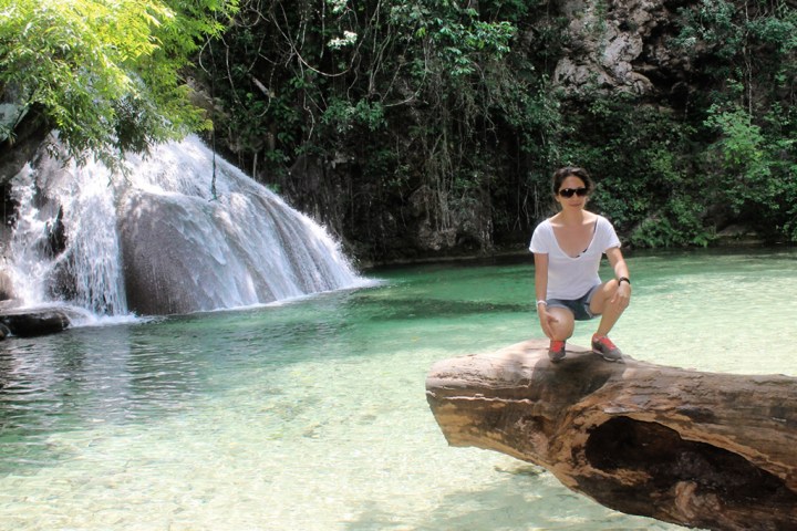 a man standing next to a waterfall