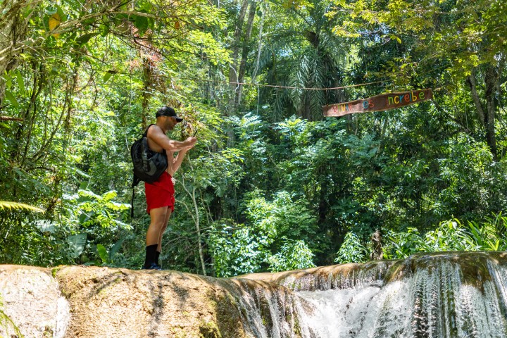 a man standing next to a forest