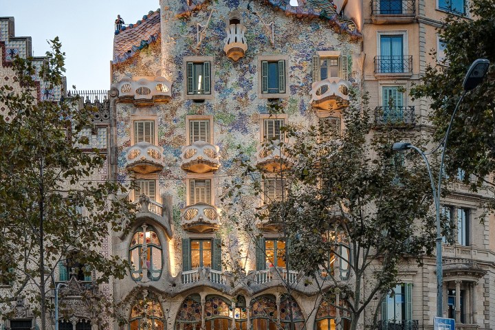 a group of people walking in front of Casa Batlló