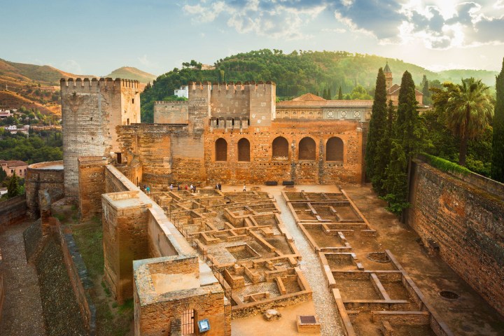 a view of a stone building with a mountain in the background