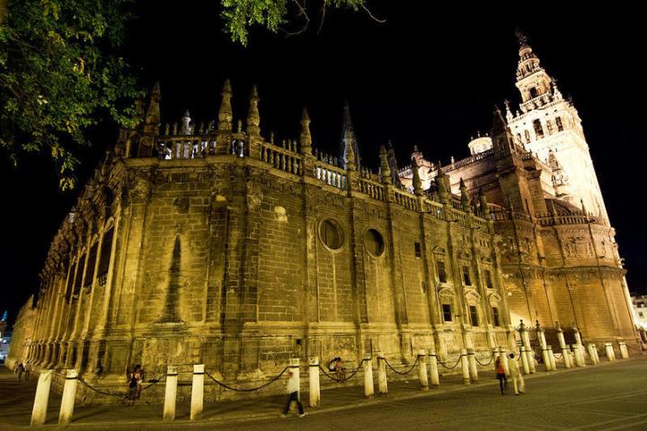 a castle with a clock tower lit up at night