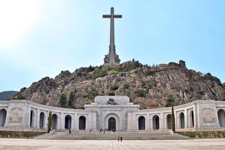 a large stone building with a mountain in the background