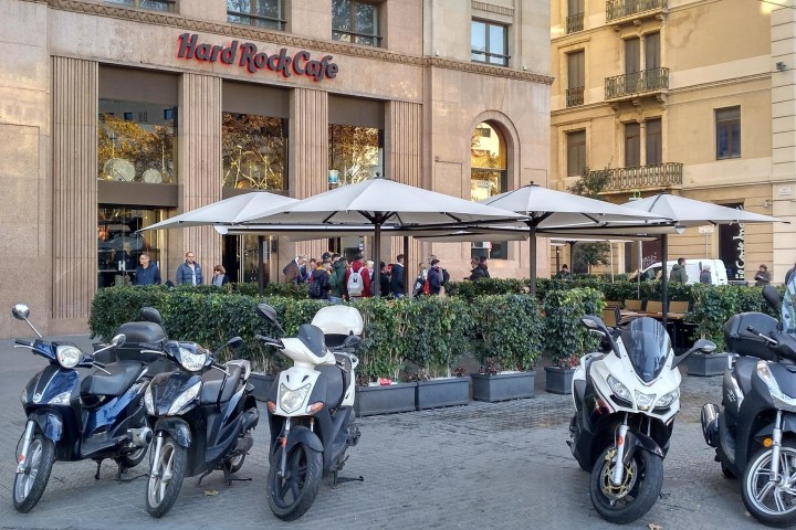 a row of parked motorcycles sitting on the side of a building