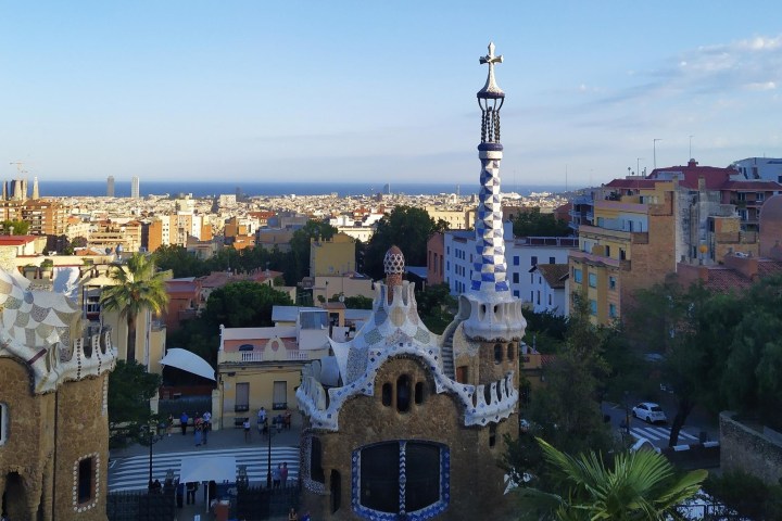 a castle with a clock at the top of Park Güell
