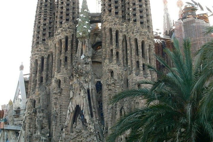 a group of people walking in front of a church with Sagrada Família in the background