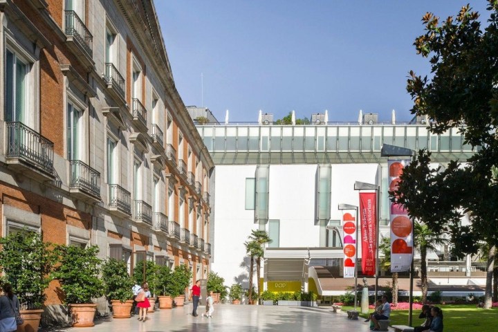 a group of people walking down a street next to a building
