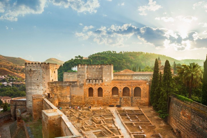 a view of a stone building with a mountain in the background