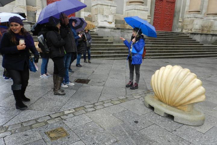 a group of people walking down a street holding an umbrella