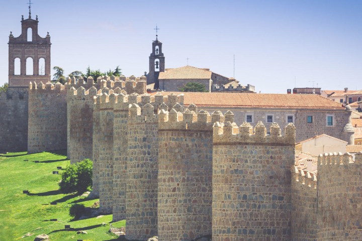 a large brick building with grass in front of a castle