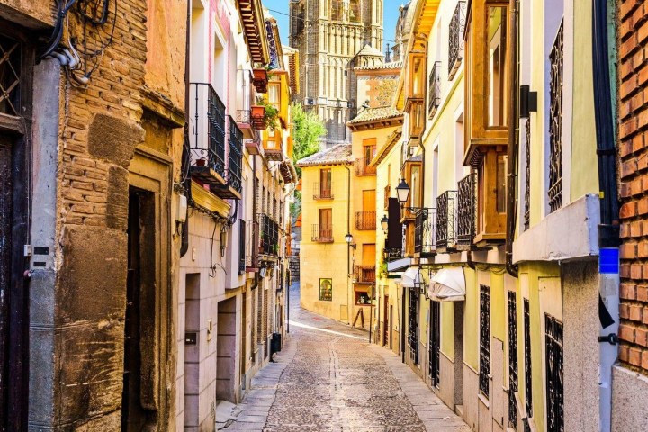a narrow city street with buildings in the background