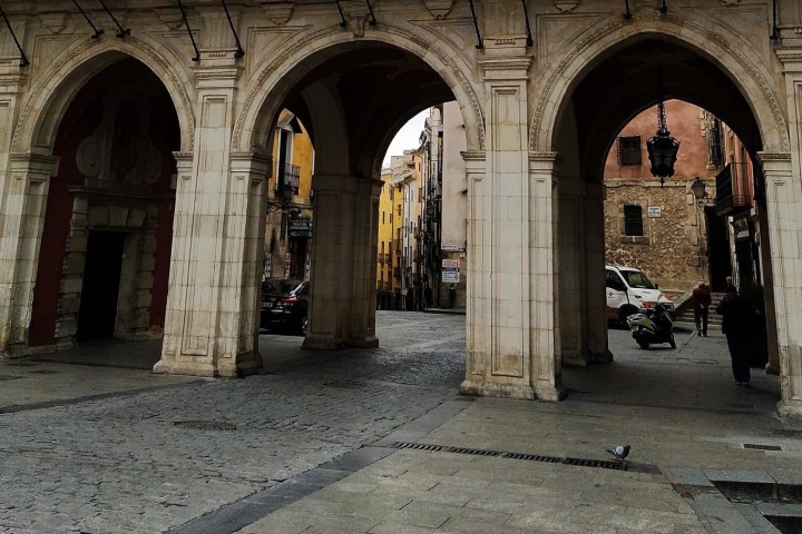 a stone building that has a bench in front of a brick wall