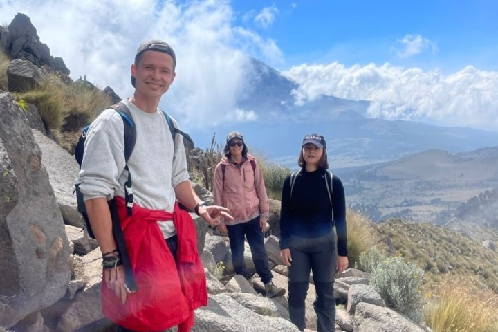 a man and a woman standing in front of a mountain