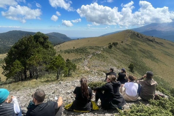 a group of people sitting on top of a mountain