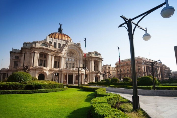 a large clock tower sitting in the grass