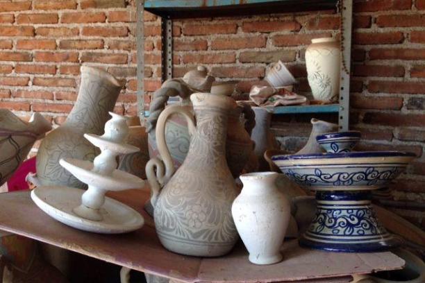 a vase sitting in front of a brick wall