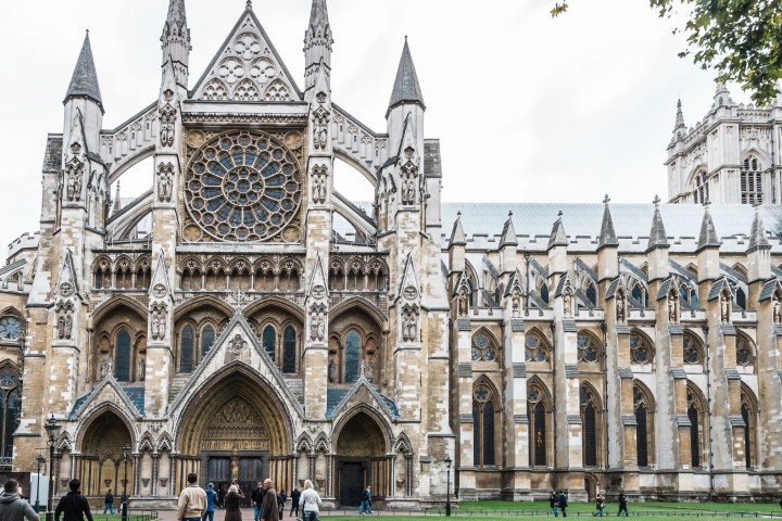a large stone building with many windows with Westminster Abbey in the background
