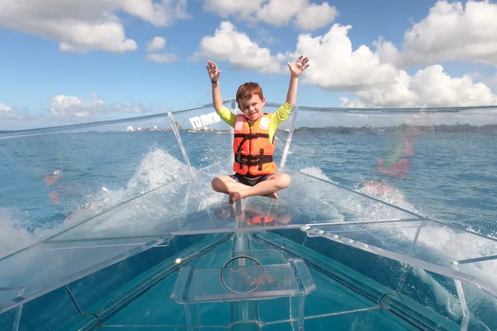 a man riding on the back of a boat in the water