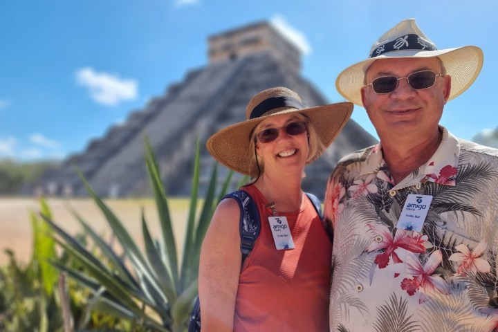 a person wearing a hat and sunglasses posing for the camera