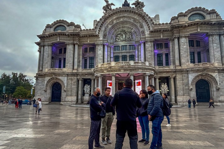 a group of people standing in front of a stone building