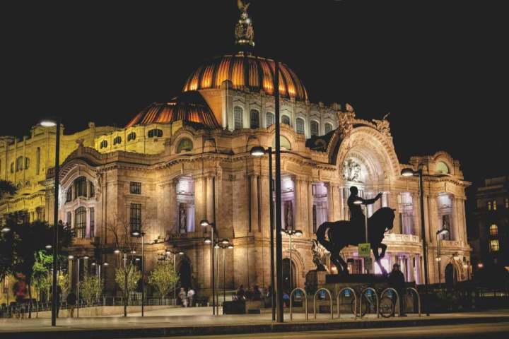 a large building in the background with Palacio de Bellas Artes in the background