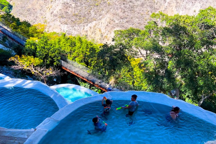 a group of people riding on the back of a pool of water