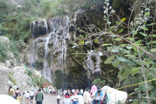 a group of people standing next to a waterfall