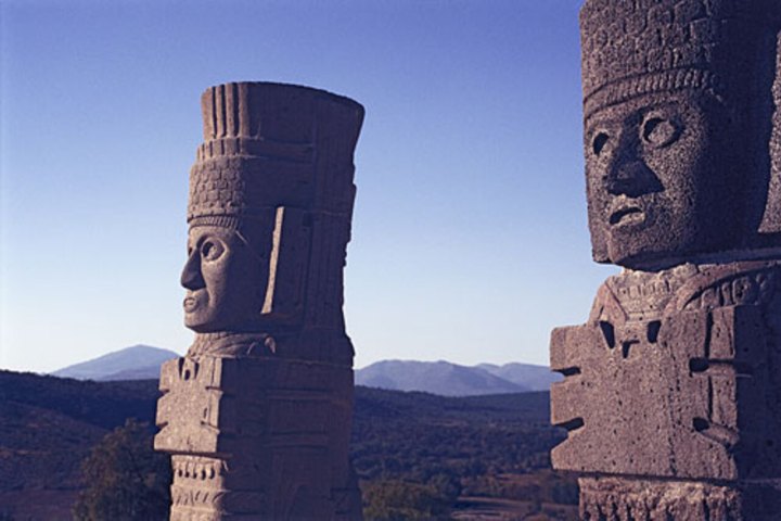 a large tall tower with a mountain in the background