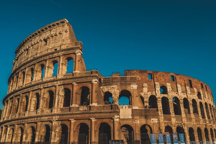 a large stone building with Colosseum in the background