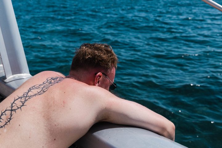 a man sitting next to a body of water