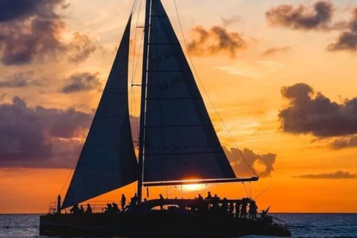 a sunset behind a boat on a body of water