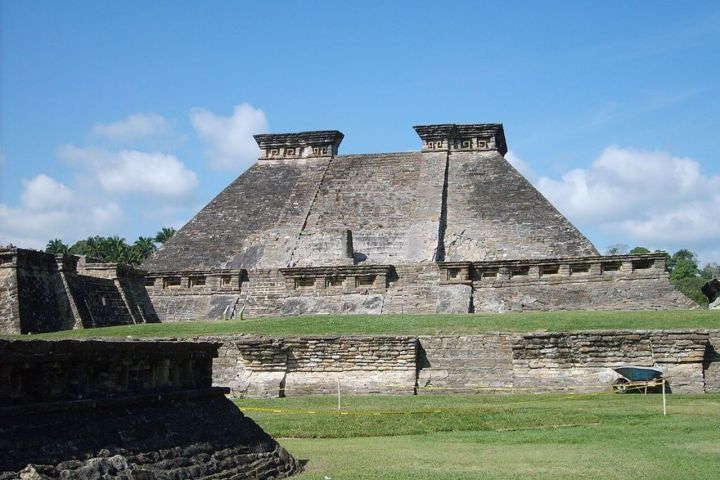 an old stone building with El Tajín in the background