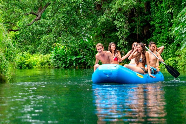 a group of people riding on the back of a boat in the water